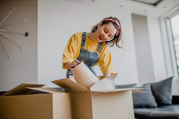 Seller packing an order into a cardboard box at home