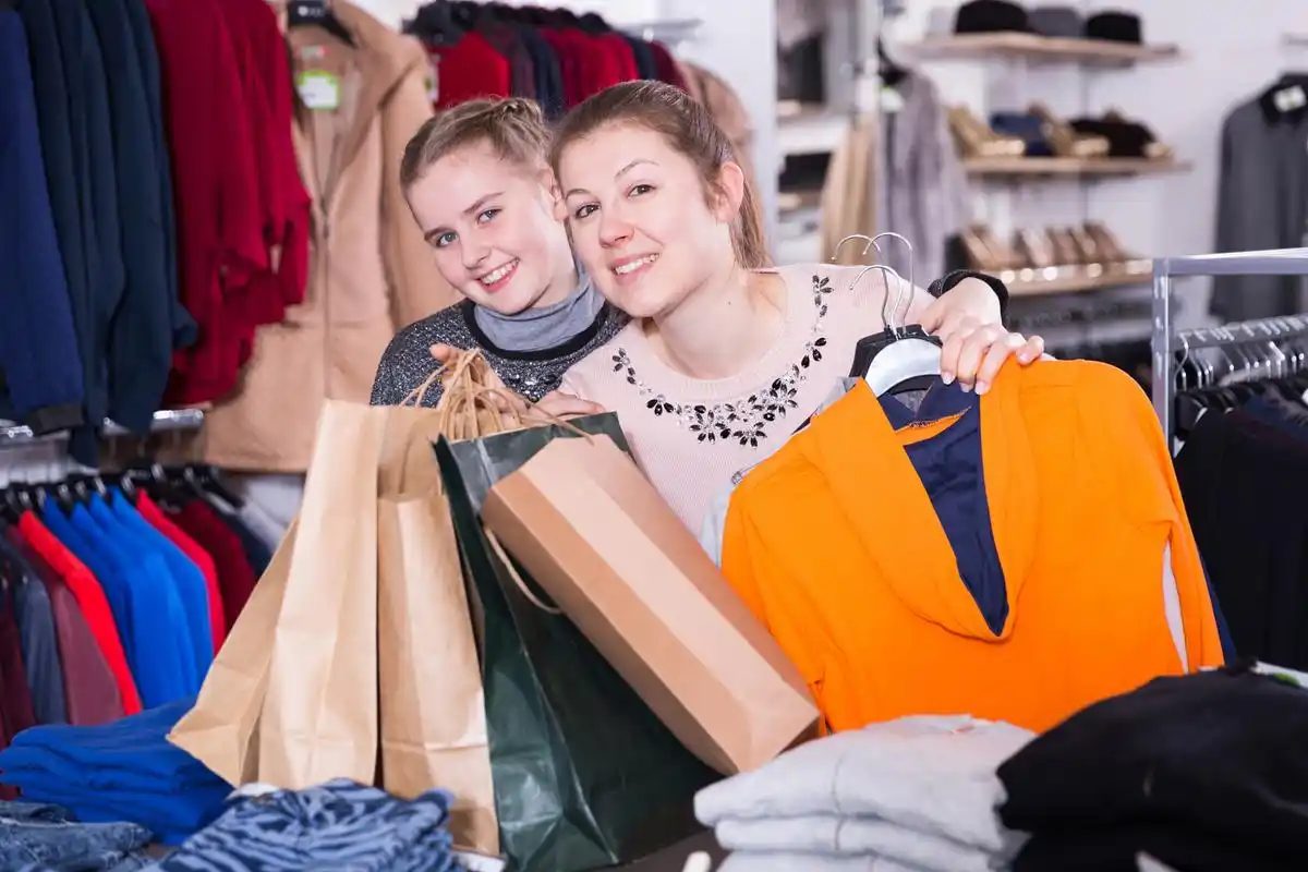 Two shoppers comparing choices in a clothing store, the same habit sellers bring to community channels